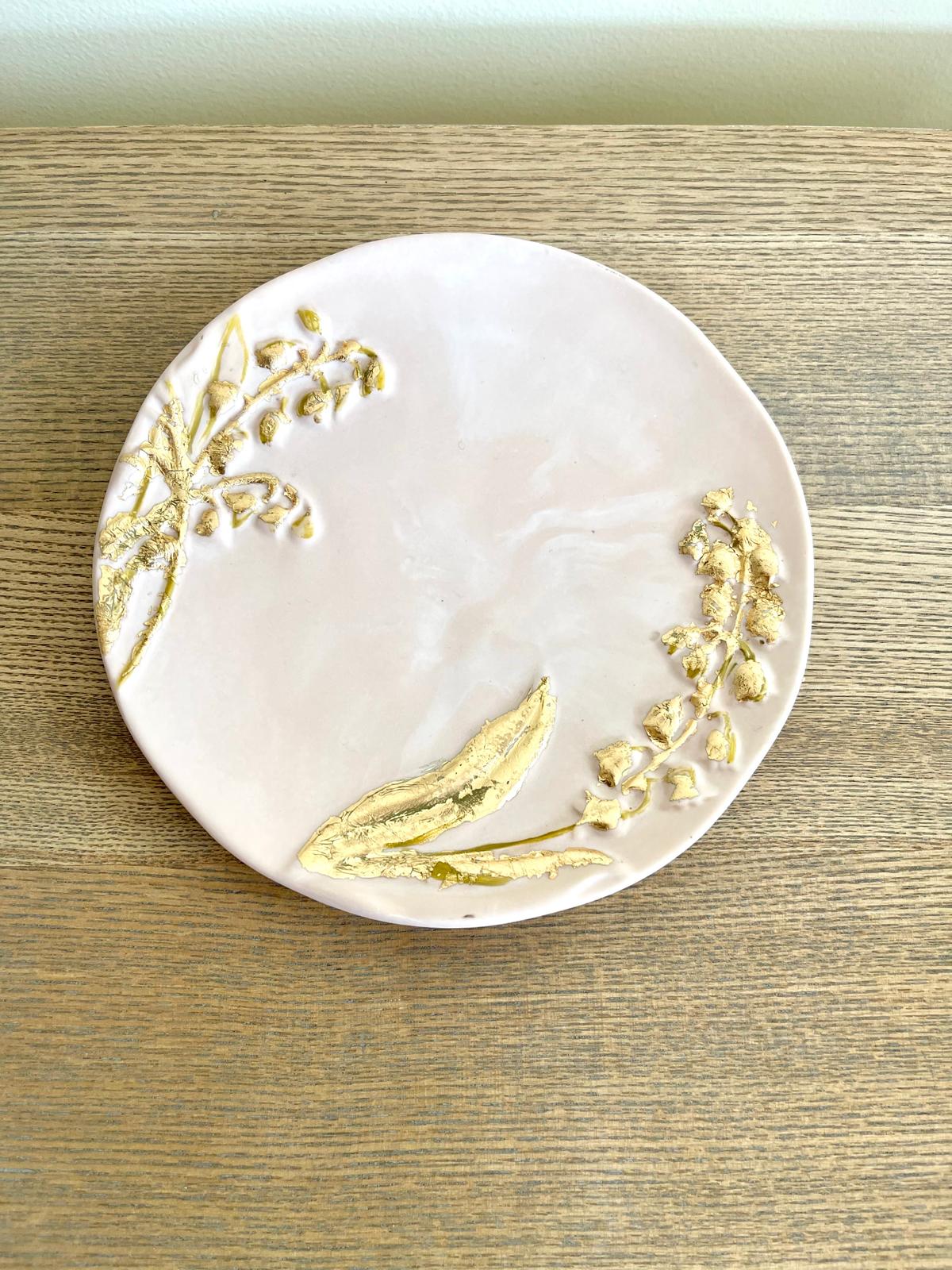 Prato decorativo em jesmonite rosa com relevo botânico dourado